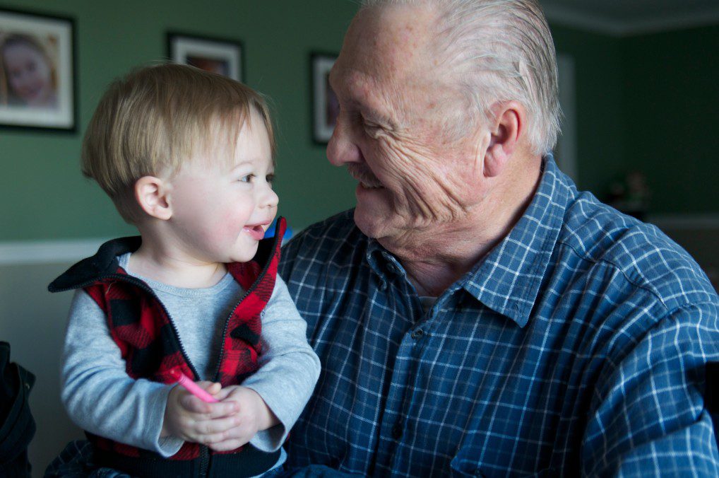 Old man carrying a baby